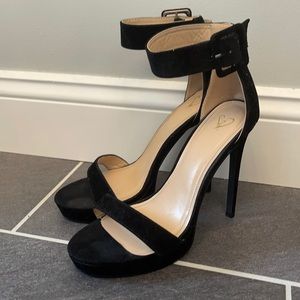 Tall, black heels with buckle strap.Size 9.